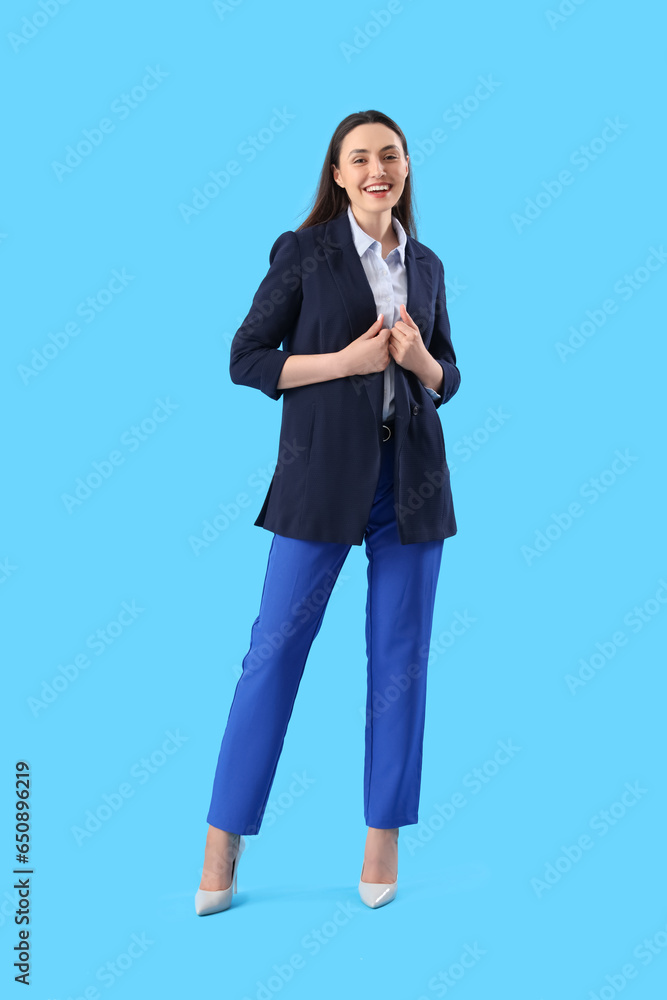 Young woman in stylish suit on blue background