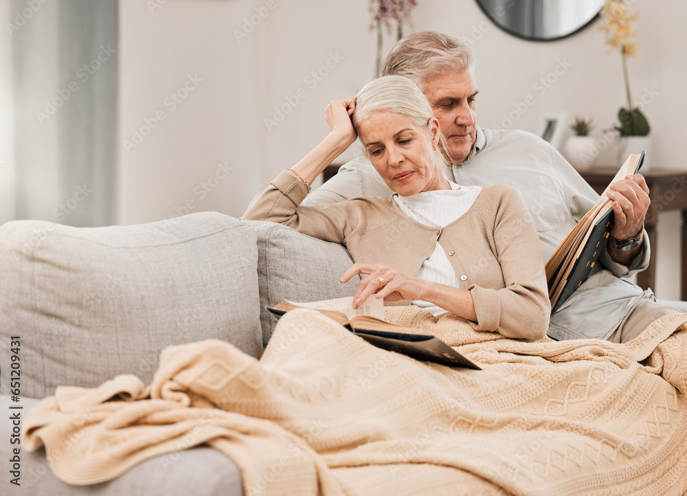 Old couple on couch, reading book and relax together at home, retirement and wellness with love and comfort. Trust, care and support in marriage, share hobby with partner for knowledge and story