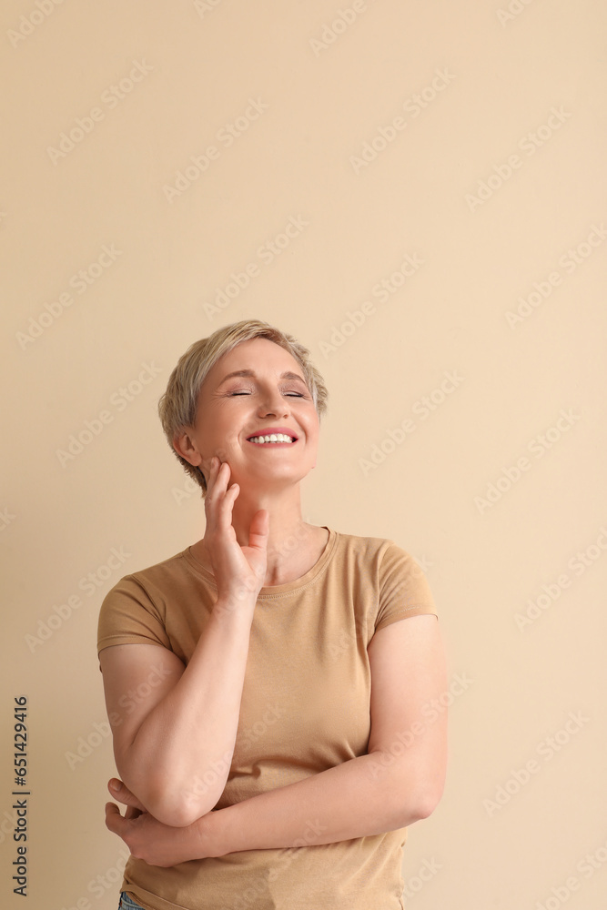 Mature blonde woman on beige background