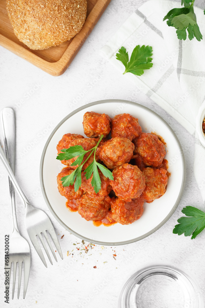 Plate of tasty meat balls with sauce on light background