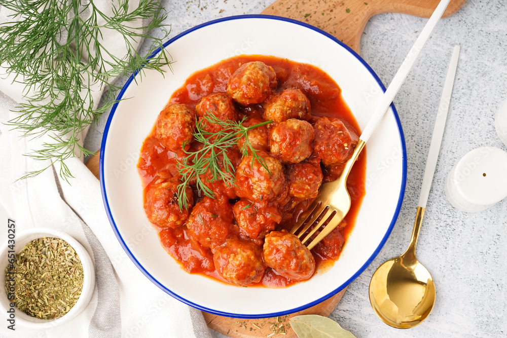 Bowl of tasty meat balls with tomato sauce and dill on white background