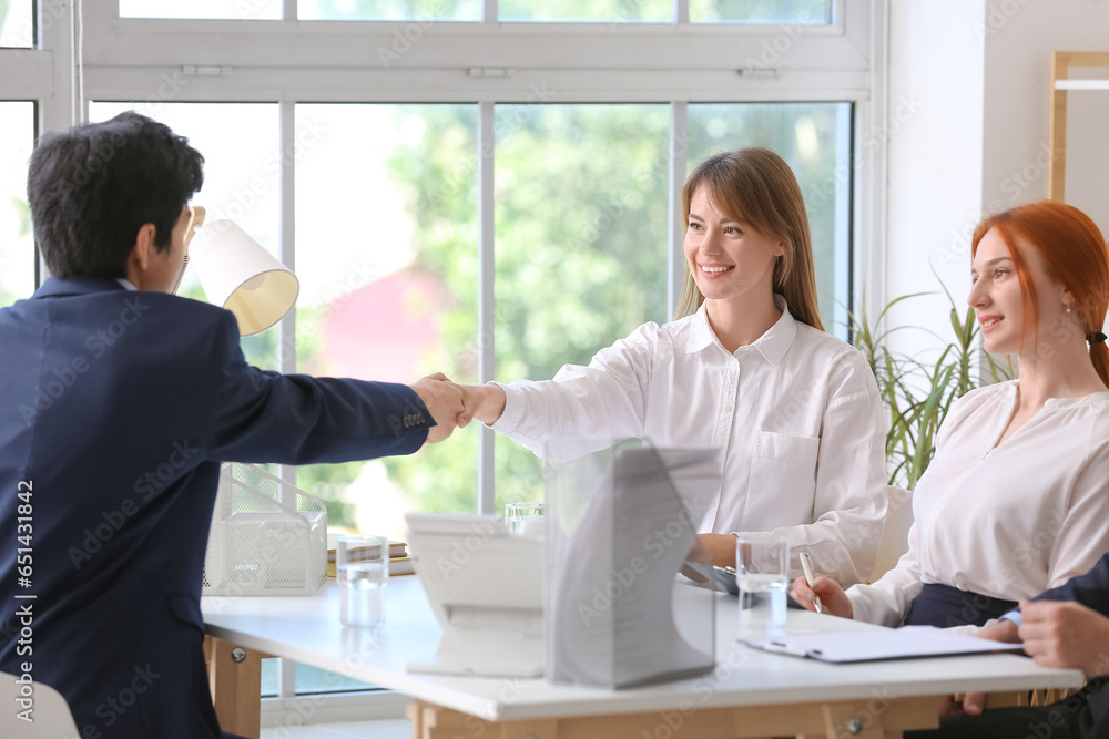 Human resources manager shaking hands with male applicant in office