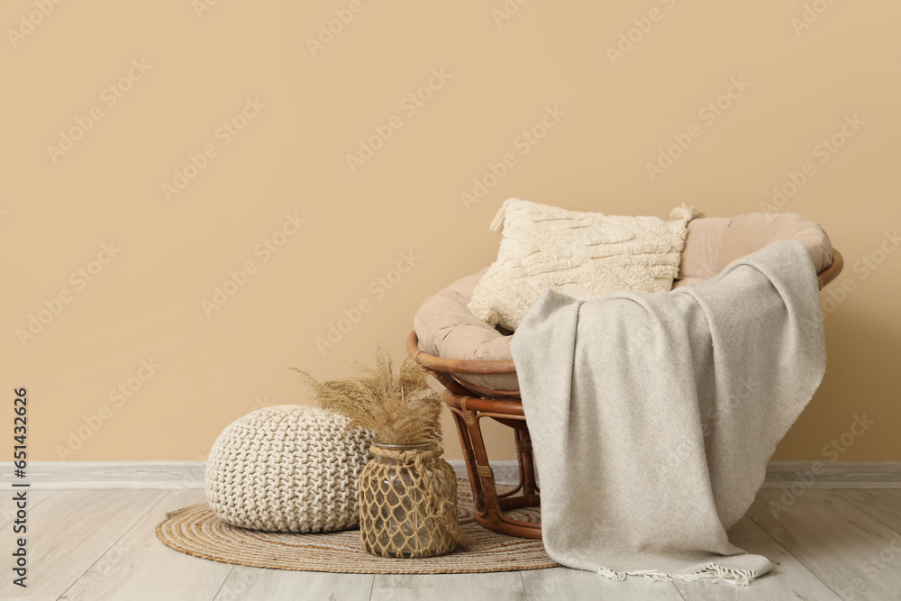 Interior of living room with plaid on armchair and pouf