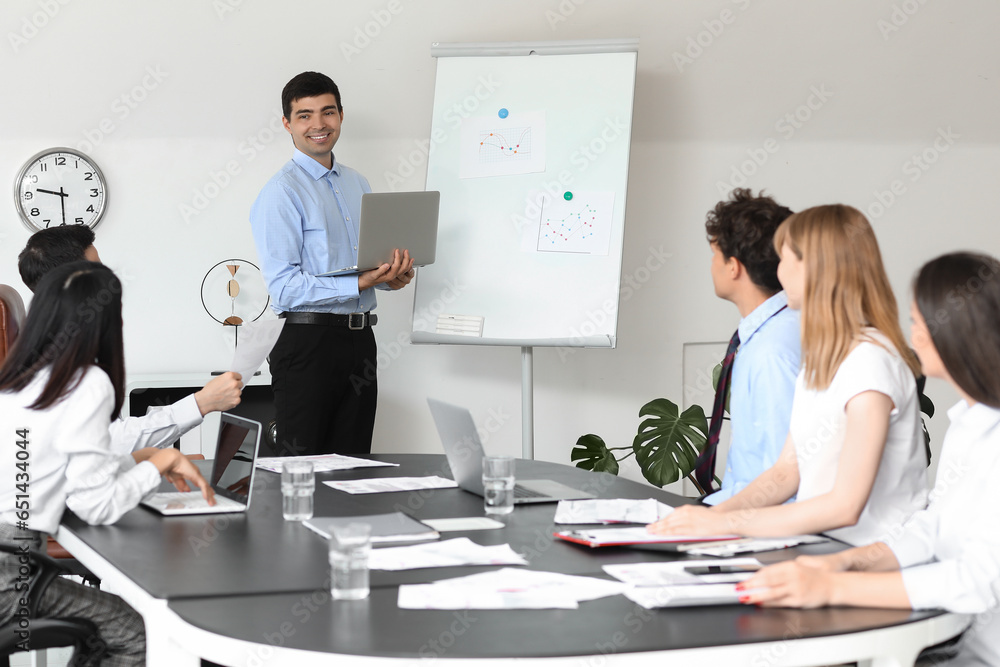 Male business consultant giving presentation to his colleagues in office