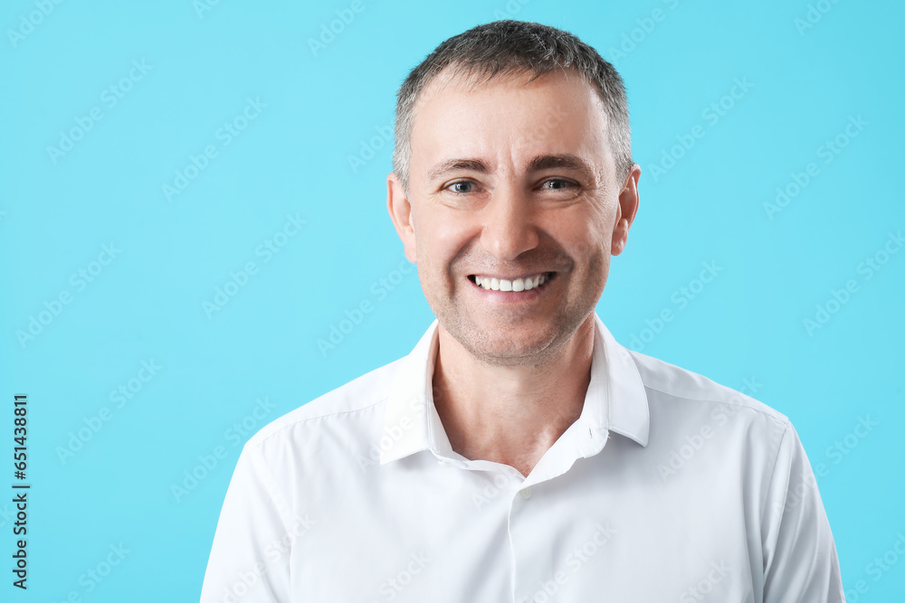 Portrait of happy mature man on blue background