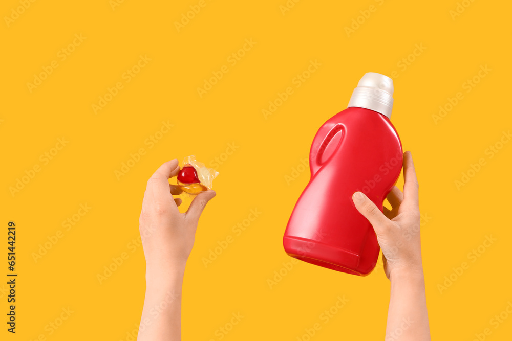 Woman with laundry detergents on orange background