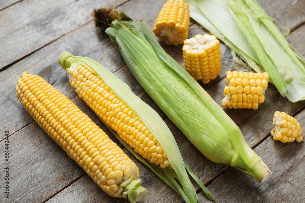 Fresh corn cobs on grey wooden table, closeup