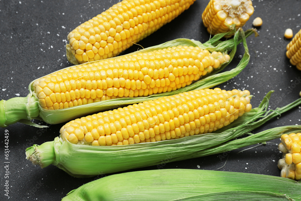 Fresh corn cobs on black table