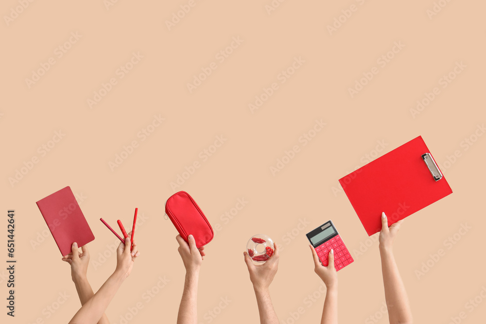 Hands holding school supplies on beige background