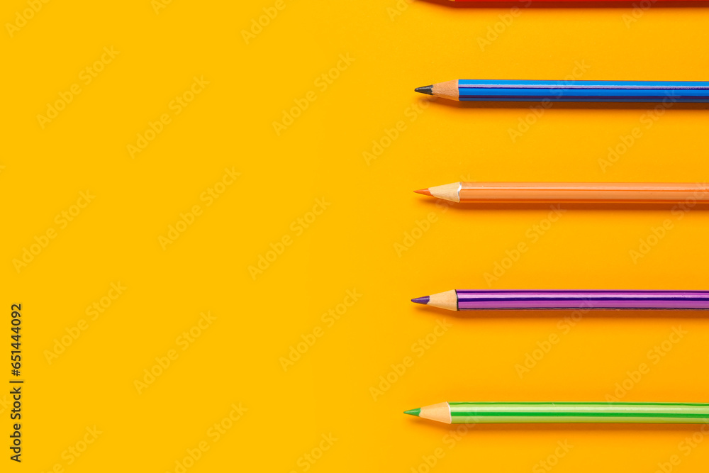 Group of colorful pencils on yellow background