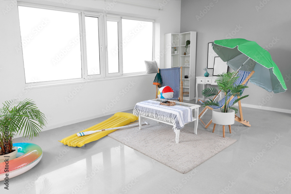 Interior of living room with deck chairs and beach accessories