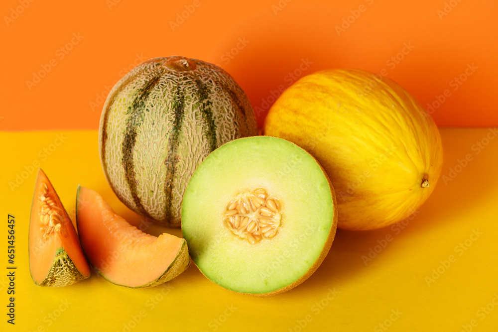 Tasty ripe melons on orange background