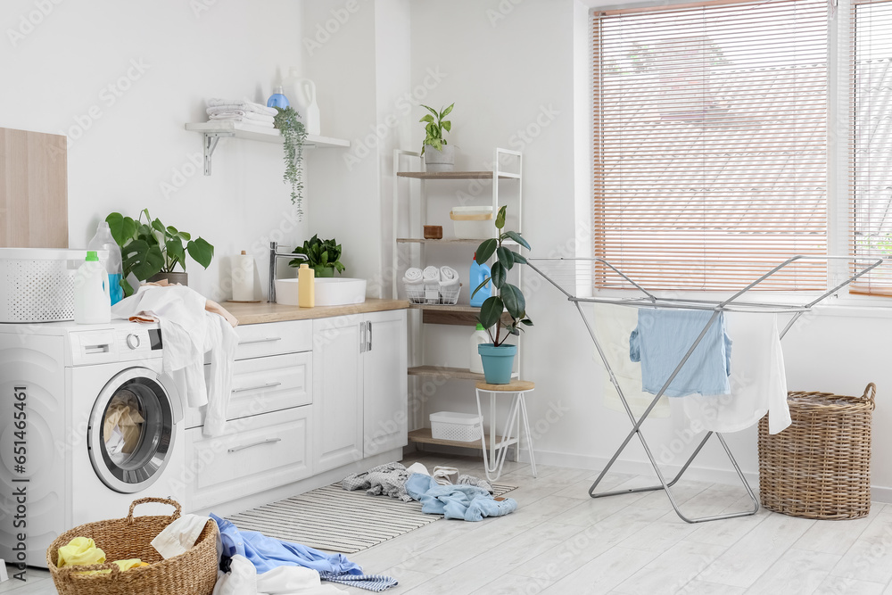 Interior of laundry room with washing machine and dirty clothes