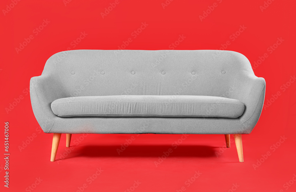 Cozy grey sofa on red background