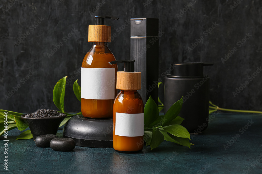 Bottles of shampoo and cosmetic products on black background