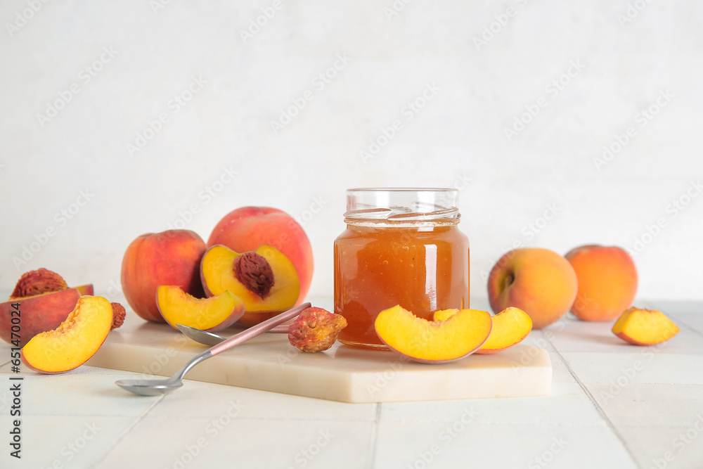 Jar with sweet peach jam and fresh fruits on table