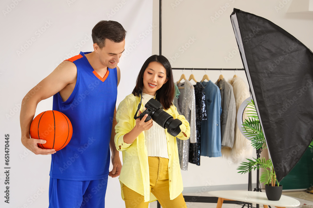 Female photographer working with basketball player in studio