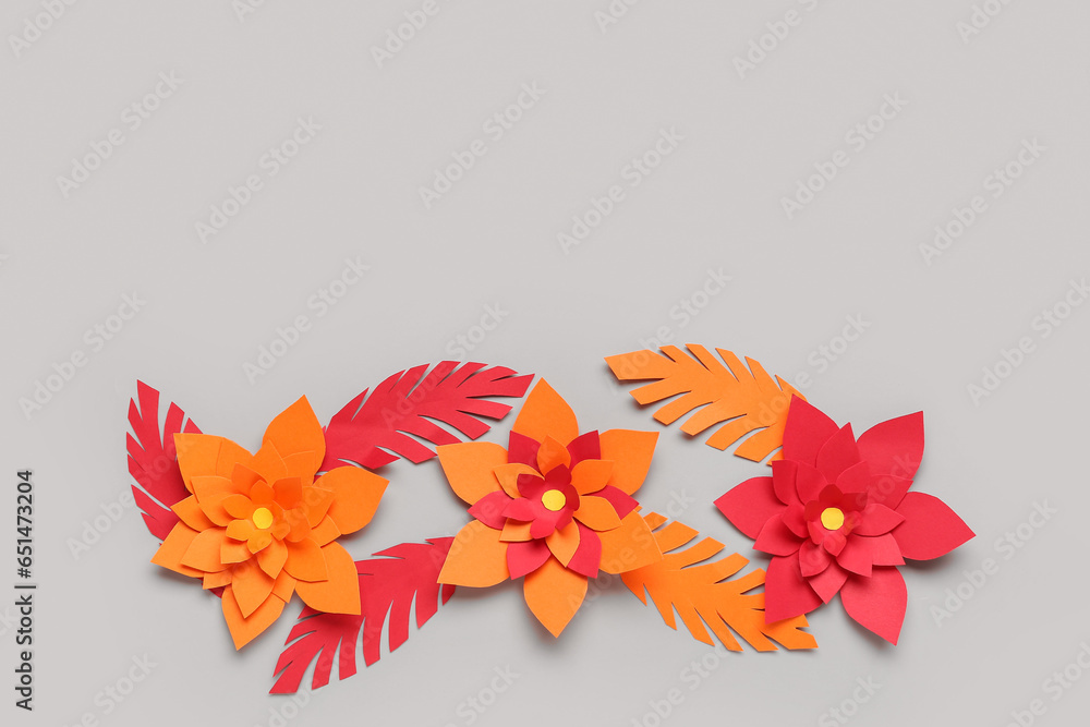 Colorful origami flowers with leaves on grey background