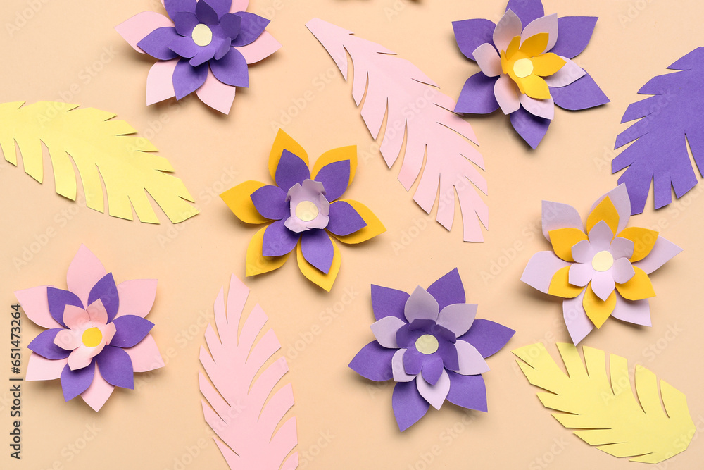 Colorful origami flowers with leaves on beige background