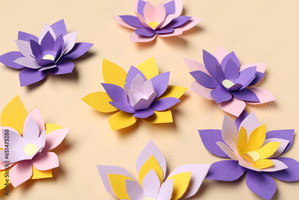 Colorful origami flowers on beige background