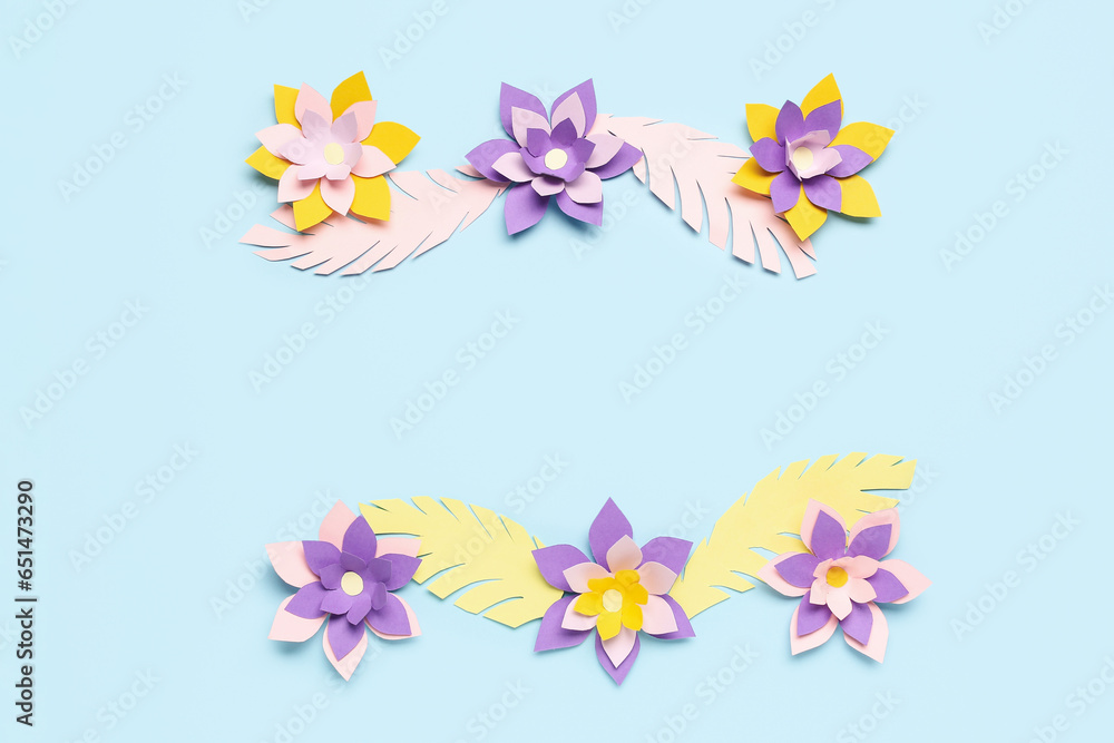 Colorful origami flowers with leaves on blue background