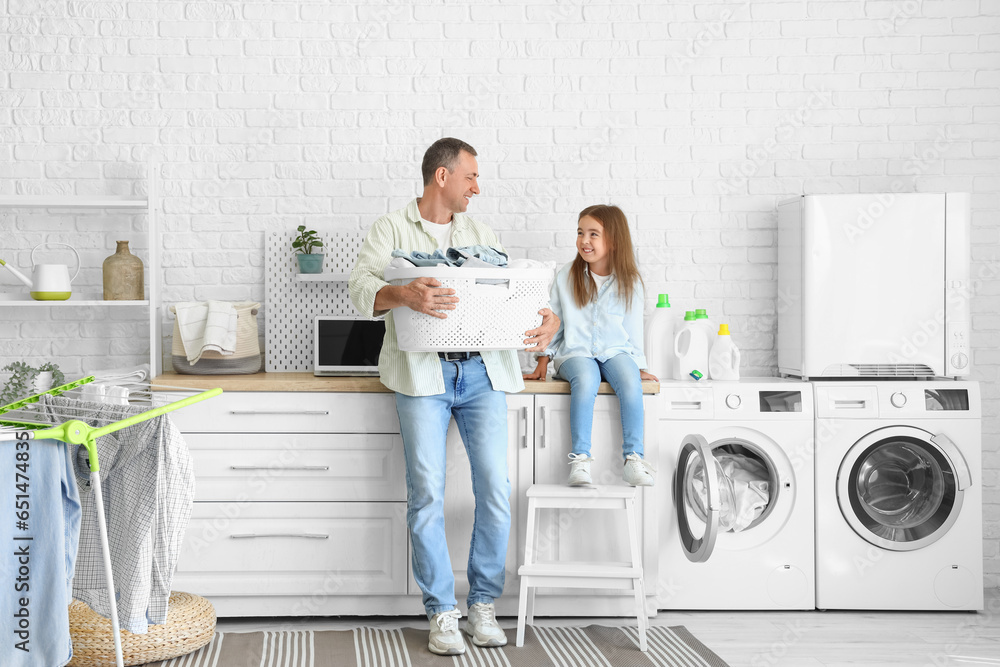 Mature man with laundry basket and his little granddaughter at home