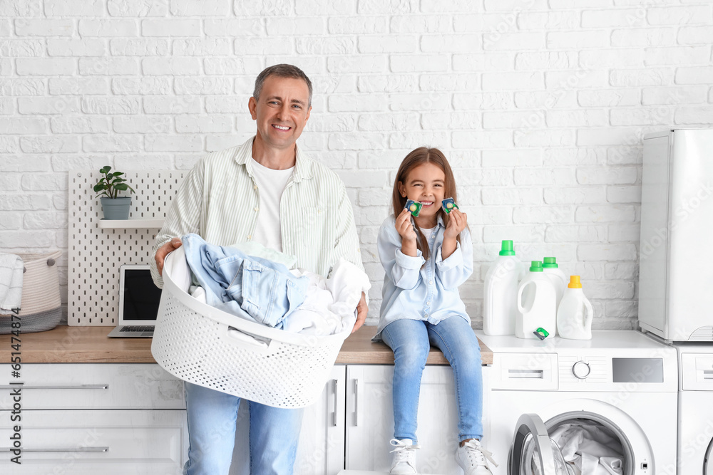 Mature man with laundry basket and his little granddaughter at home