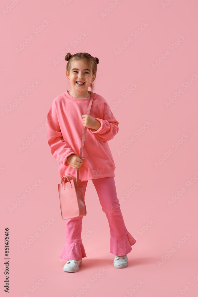 Stylish little girl on pink background