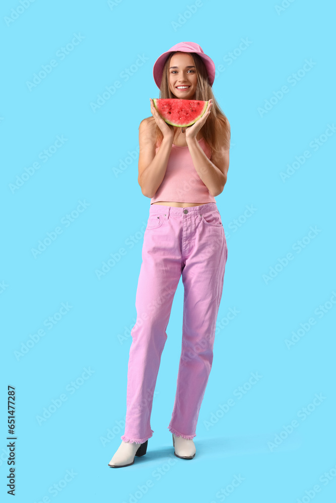 Young woman with fresh watermelon on blue background