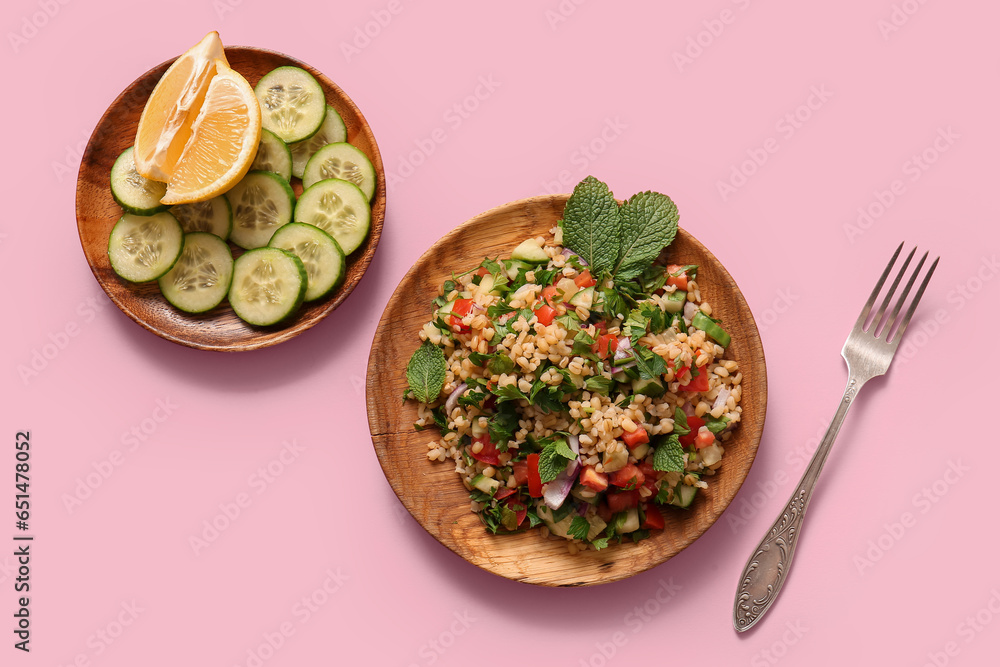 Plate with delicious tabbouleh salad and ingredients on pink background