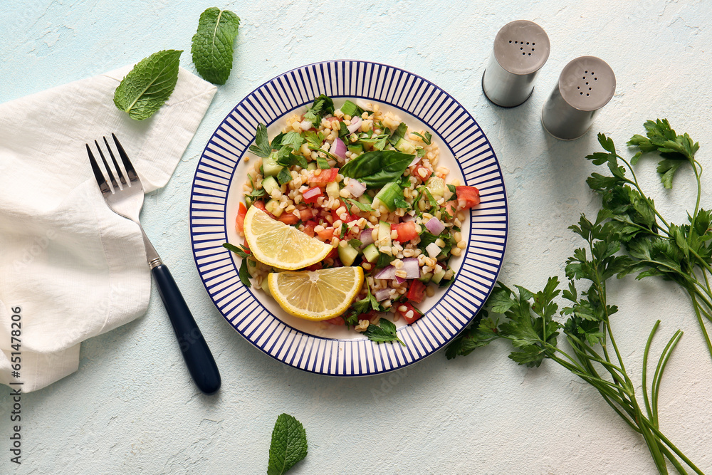 Plate with delicious tabbouleh salad on light background