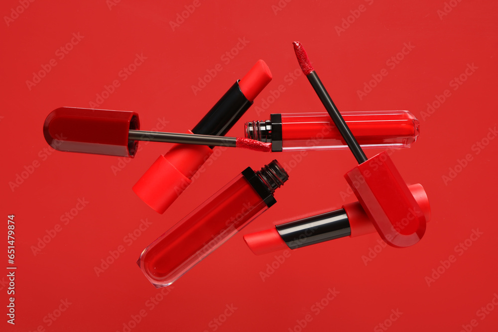 Lipsticks flying on red background