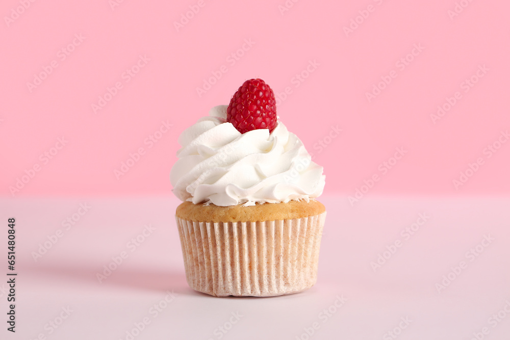 Tasty raspberry cupcake on pink background