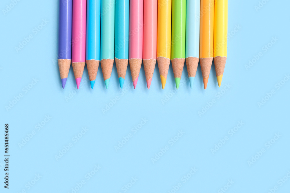 Many colorful pencils on blue background