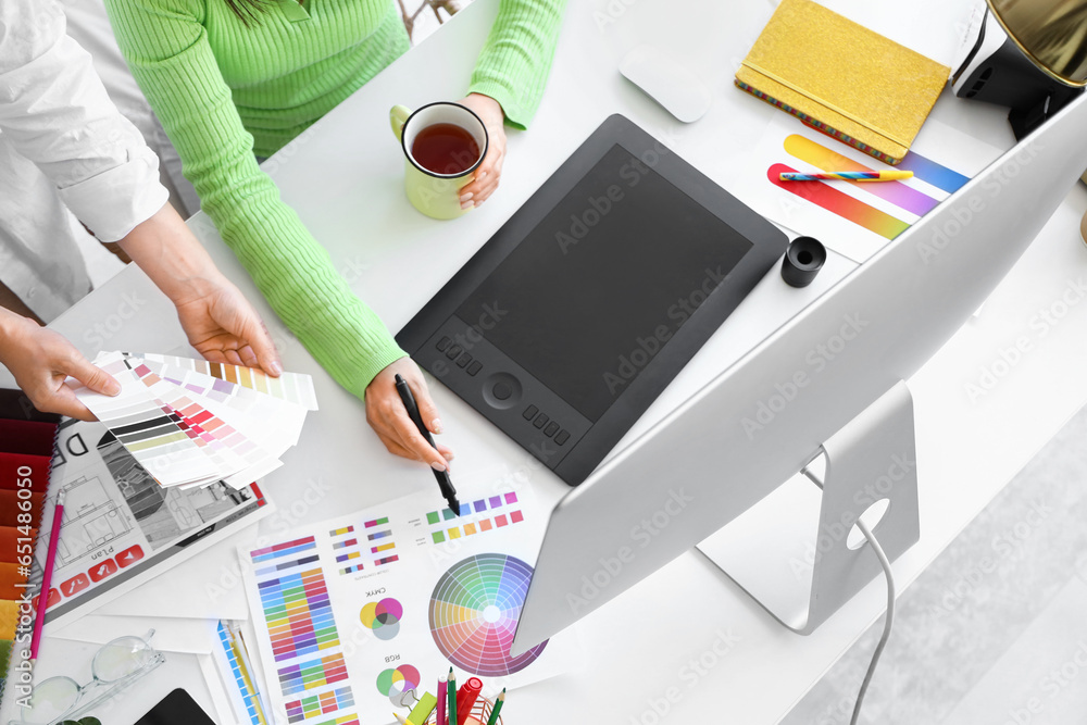 Female interior designers working at table in office, top view