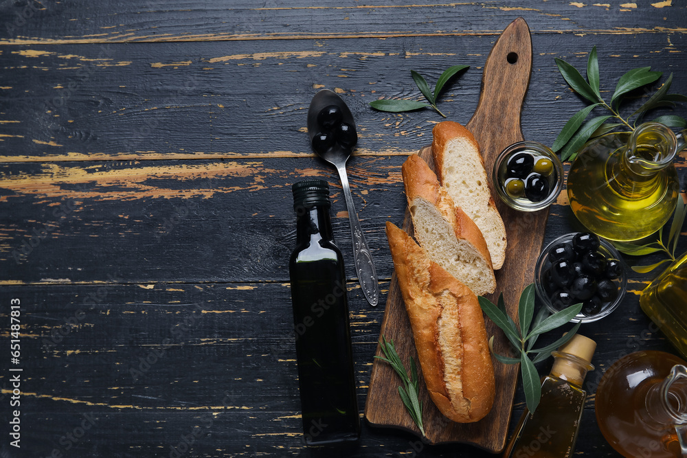 Different glassware with fresh olive oil and bread on black wooden background