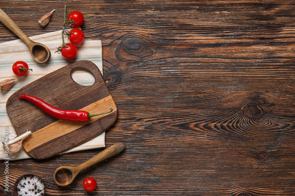 Cutting board with spoons fresh products on brown wooden kitchen table