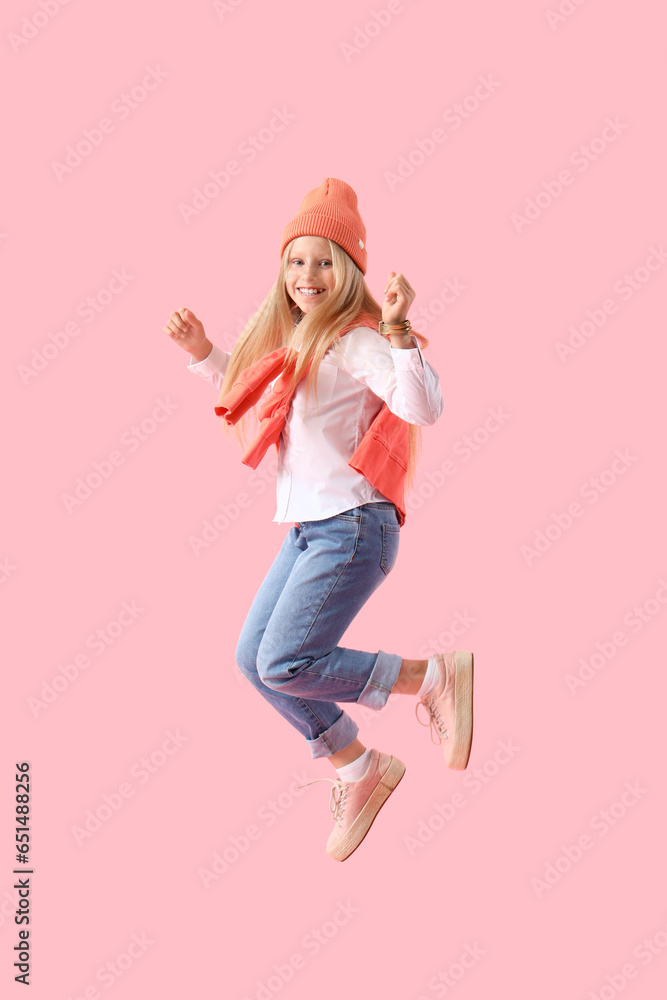 Jumping little girl on pink background