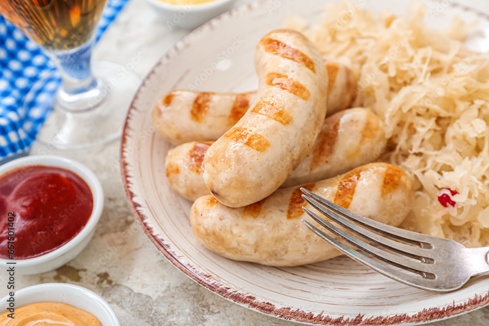 Plate with tasty Bavarian sausages, sauerkraut and sauces on beige background. Oktoberfest celebration