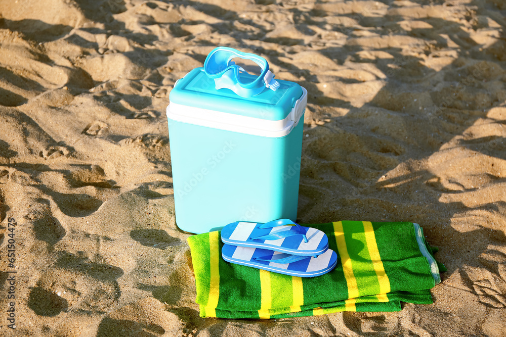 Beach cooler and accessories on sand