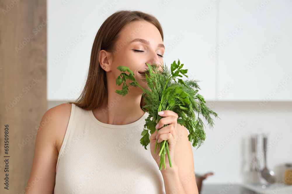 Young woman with herbs cooking in kitchen, closeup