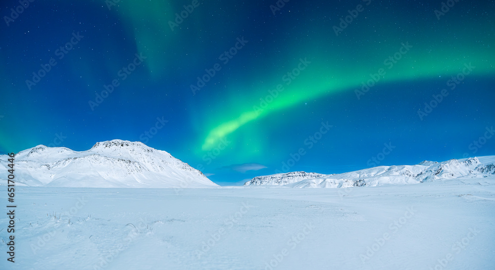 Aurora Borealis. Northern lights and clear skies. Nature. Scandinavian countries. Snow and ice on the mountains. Landscape in winter time. Photo for background and wallpaper.