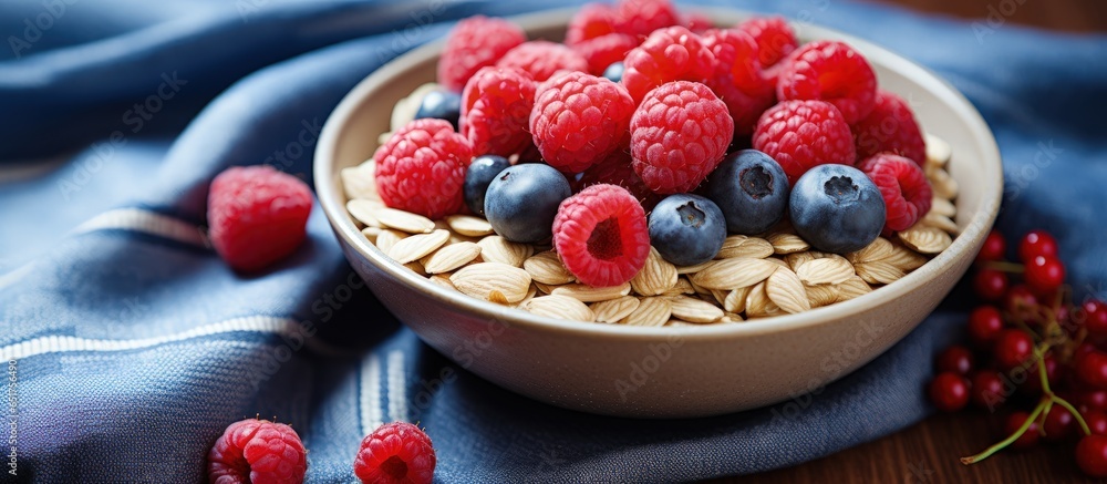 Close up of a healthy breakfast bowl with oatmeal blueberries raspberries almonds and muesli on a red plaid background representing a healthy lifestyle concept