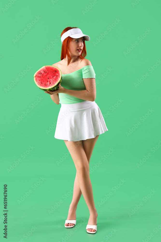 Young woman with fresh watermelon on green background