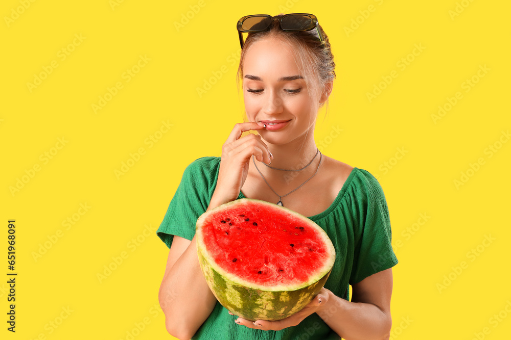 Young woman with fresh watermelon on yellow background