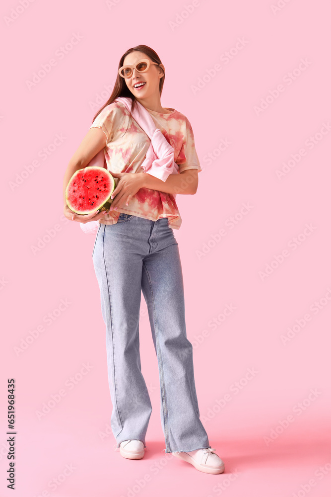 Young woman with fresh watermelon on pink background