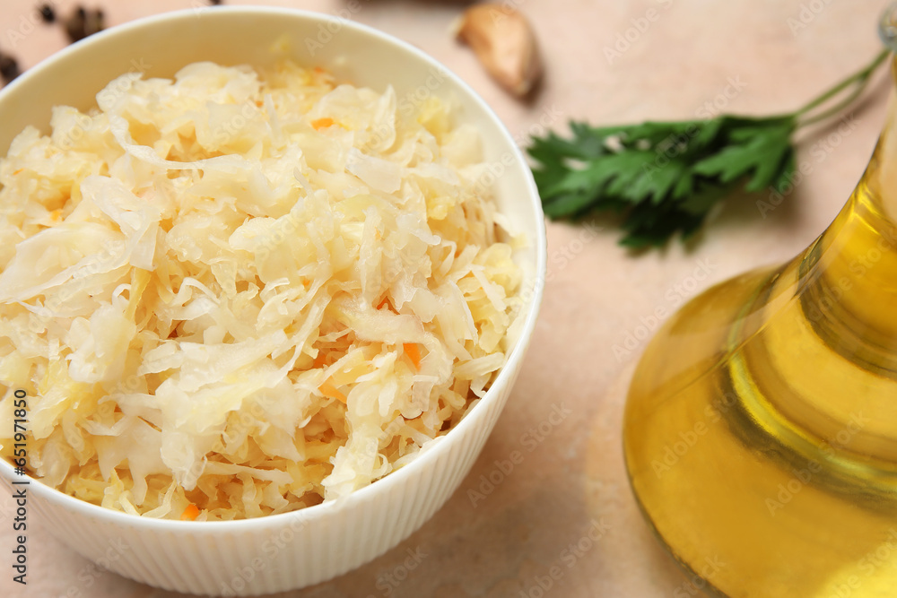 Bowl with delicious sauerkraut on pink background