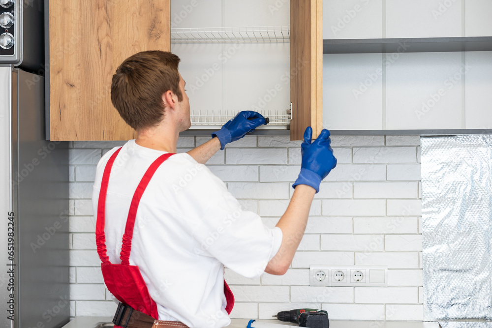 Worker installing new countertop in modern kitchen