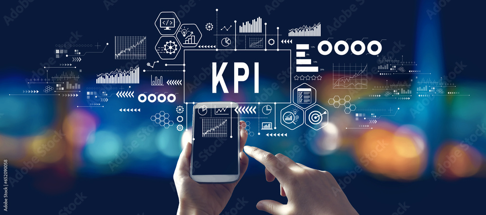 KPI - Key Performance Indicator theme with person using a smartphone in a city at night