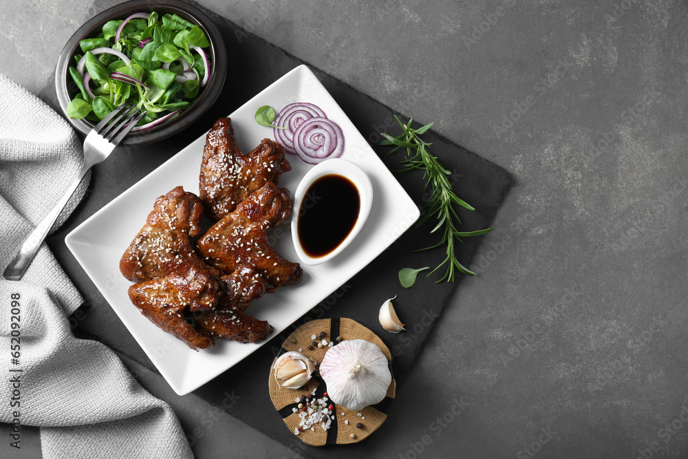 Chicken wings glazed with soy sauce served on grey table, flat lay. Space for text